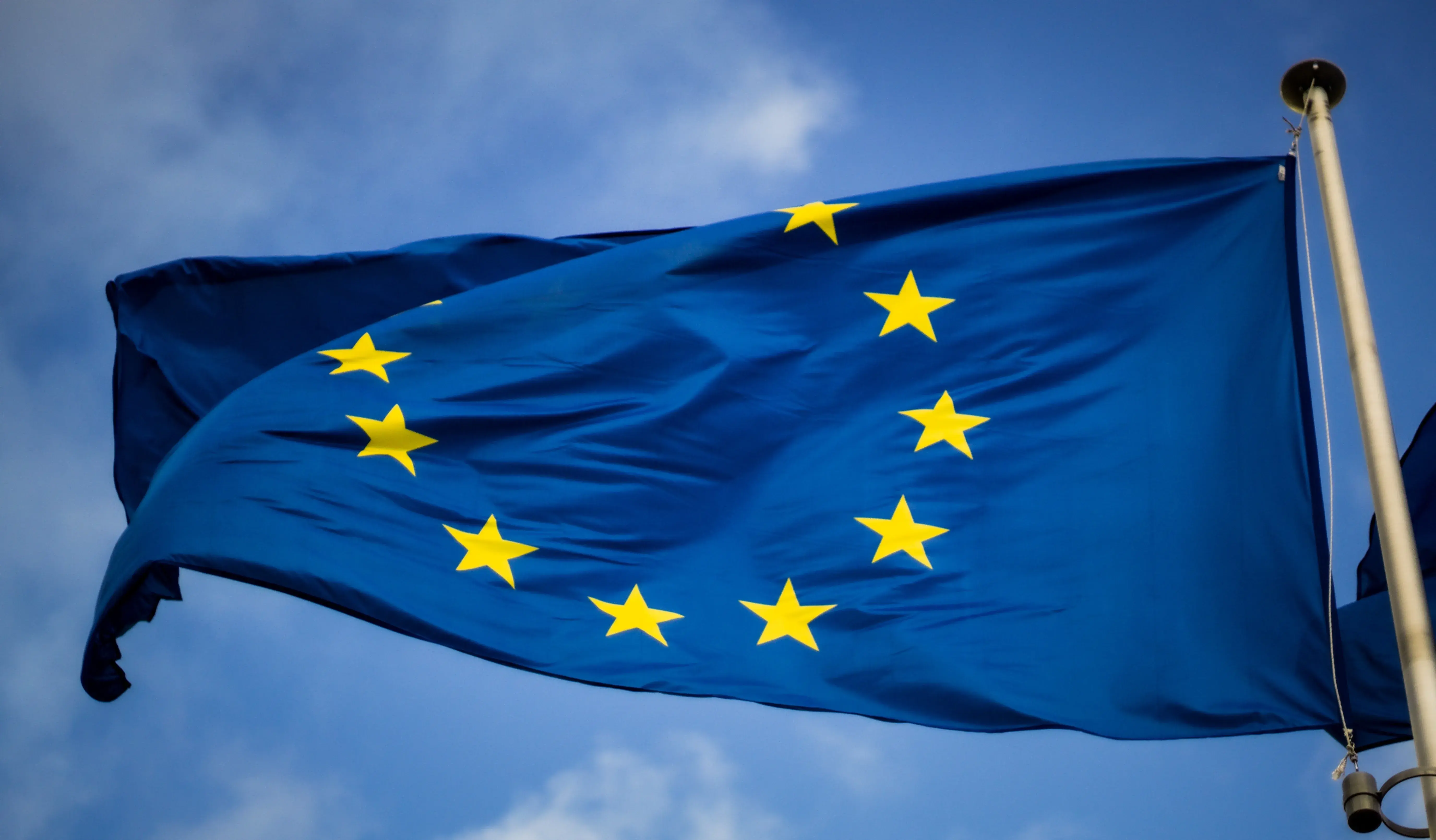 European Union flag beside a passport, symbolizing free movement rights for family members of EU citizens